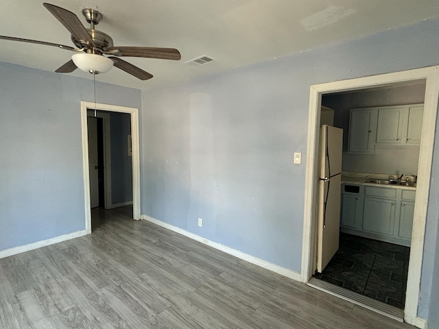 unfurnished room with light hardwood / wood-style flooring, ceiling fan, and sink