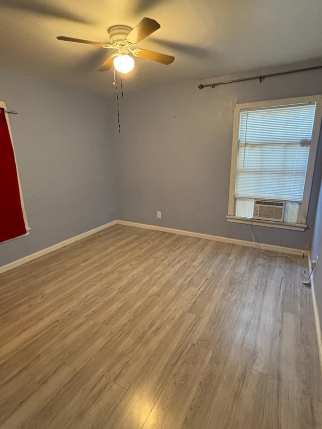 unfurnished room featuring cooling unit, hardwood / wood-style floors, and ceiling fan