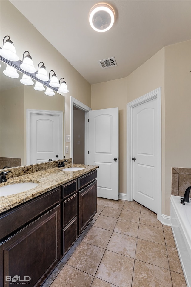 bathroom featuring tile patterned floors, vanity, and a tub