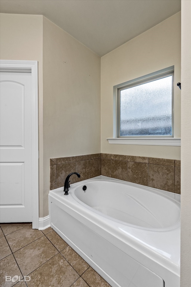 bathroom with tile patterned flooring and a tub to relax in