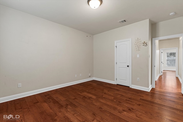 empty room with dark wood-type flooring