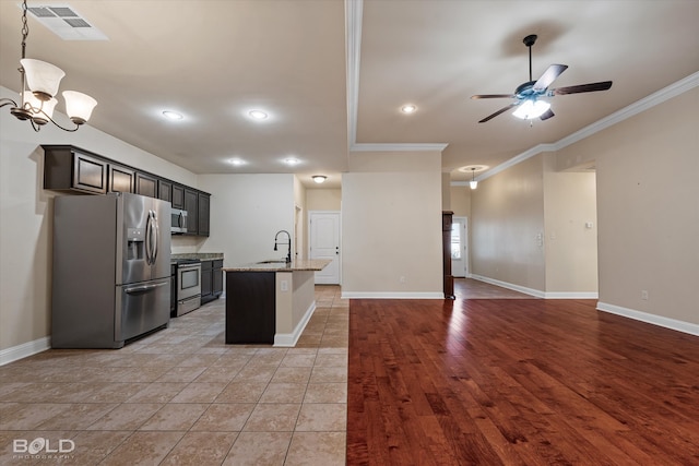 kitchen featuring stainless steel appliances, light stone counters, light hardwood / wood-style floors, a kitchen island with sink, and ornamental molding