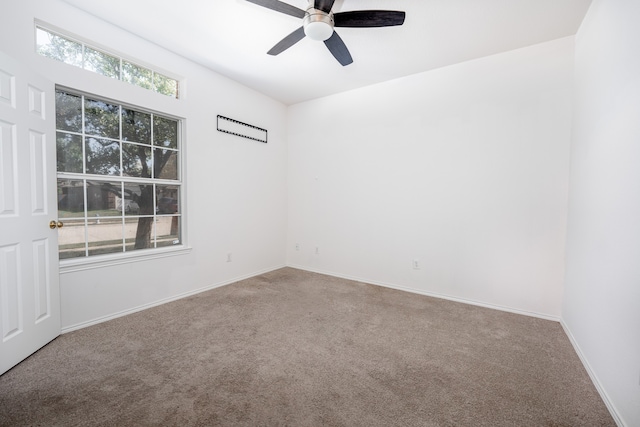 carpeted spare room with ceiling fan and plenty of natural light