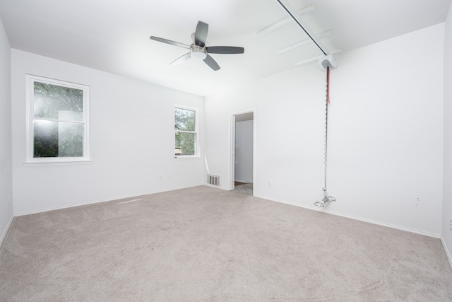 carpeted spare room featuring ceiling fan