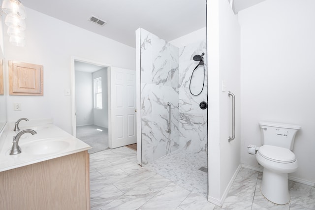 bathroom featuring a tile shower, vanity, and toilet