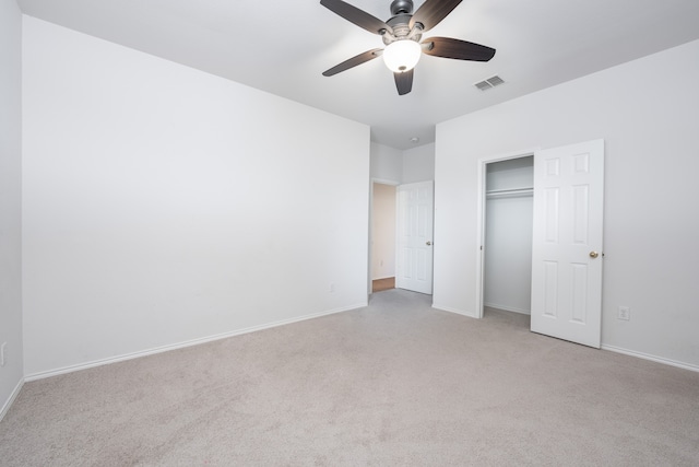 unfurnished bedroom featuring light carpet, ceiling fan, and a closet