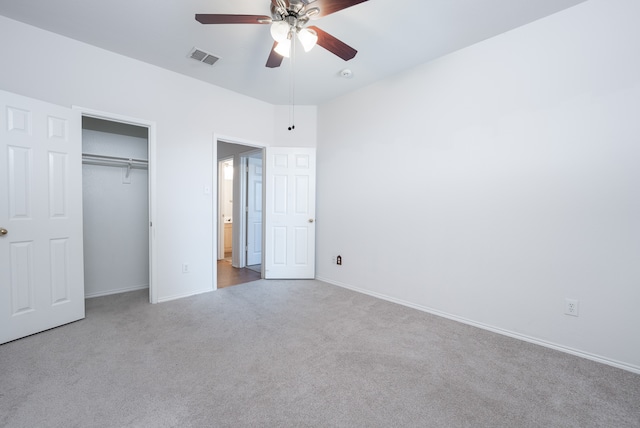 unfurnished bedroom featuring ceiling fan, light colored carpet, and a closet