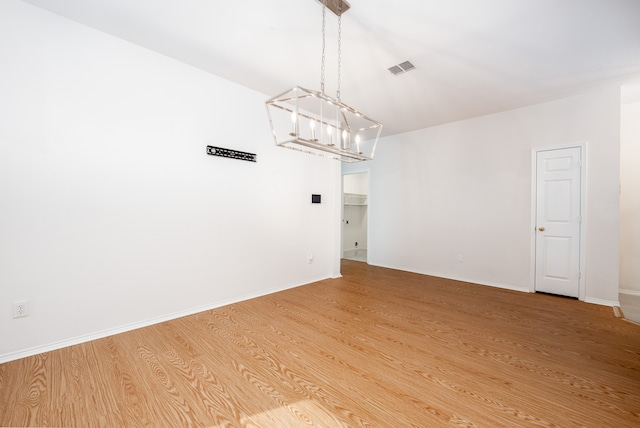 unfurnished dining area with a chandelier and hardwood / wood-style flooring