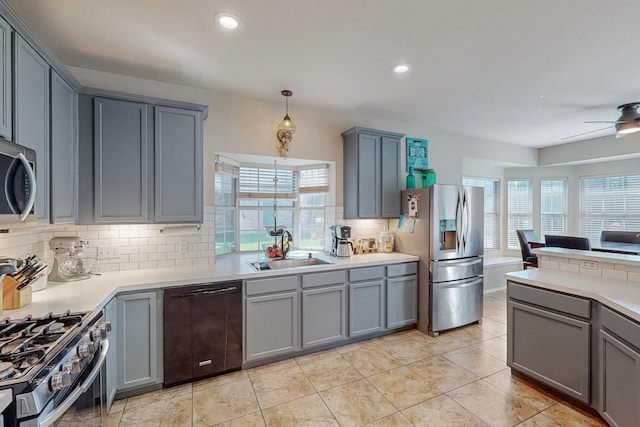 kitchen with appliances with stainless steel finishes, sink, pendant lighting, and plenty of natural light