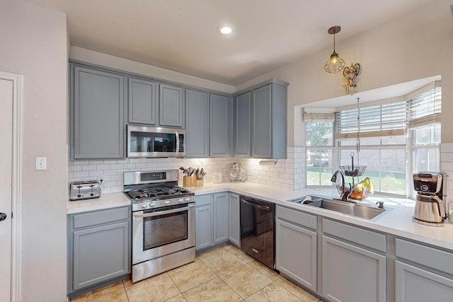 kitchen featuring appliances with stainless steel finishes, sink, pendant lighting, and gray cabinets