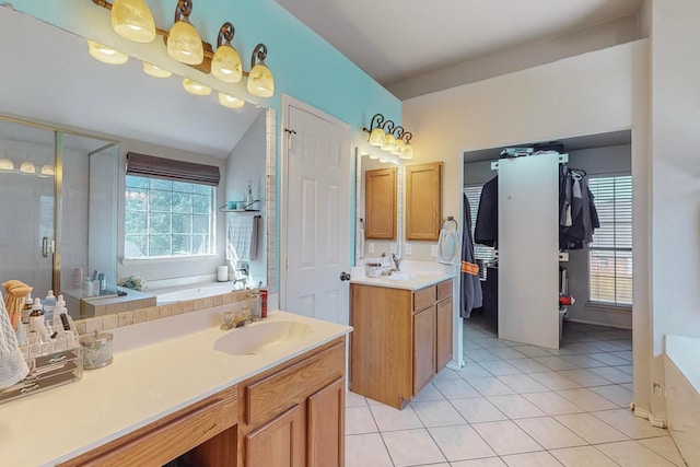 bathroom with tile patterned floors, independent shower and bath, vanity, and vaulted ceiling