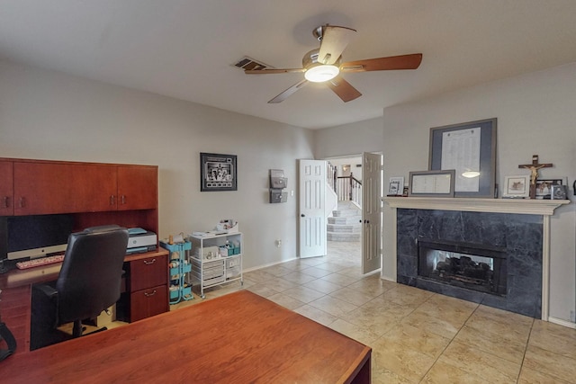 tiled home office with a fireplace and ceiling fan