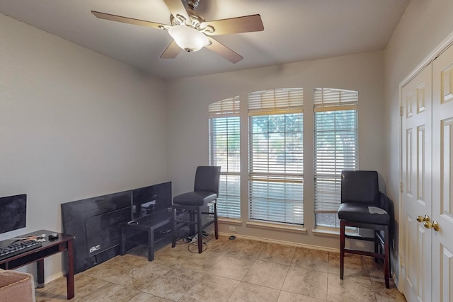 living area featuring ceiling fan and a healthy amount of sunlight