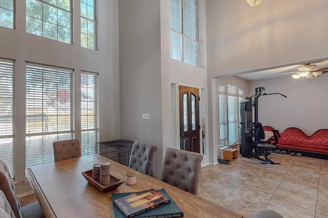 dining space with ceiling fan and a high ceiling