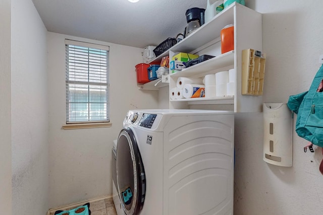 laundry room with washing machine and clothes dryer and a textured ceiling