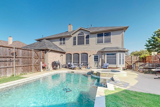 view of swimming pool featuring an in ground hot tub and a patio area