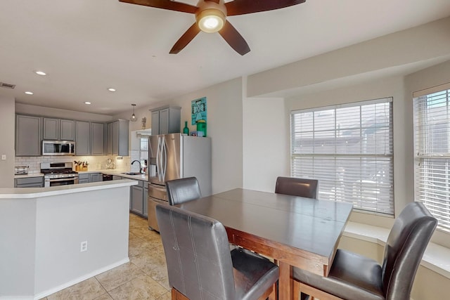 dining area featuring light tile patterned floors, sink, and ceiling fan