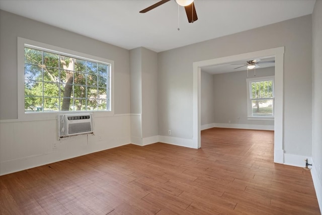 empty room featuring a healthy amount of sunlight, ceiling fan, light hardwood / wood-style flooring, and cooling unit