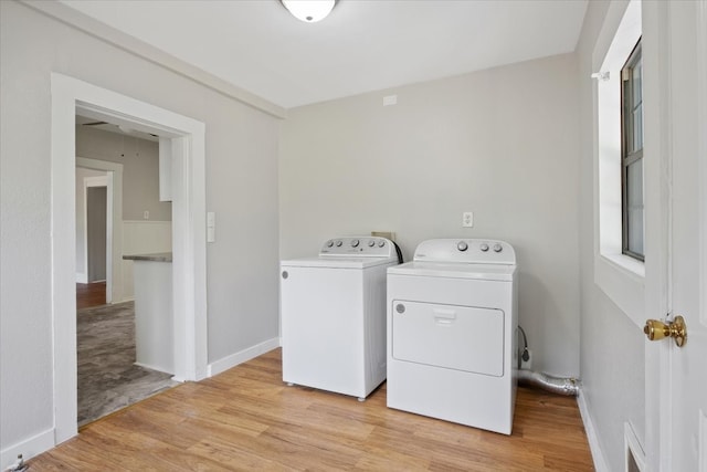 laundry area with independent washer and dryer and light hardwood / wood-style flooring