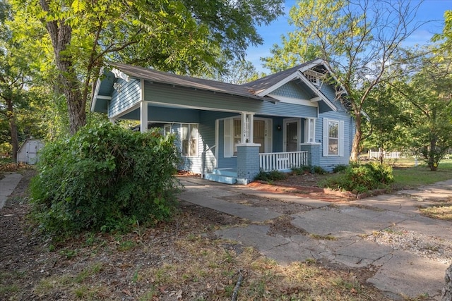 view of front of house featuring a shed and a porch