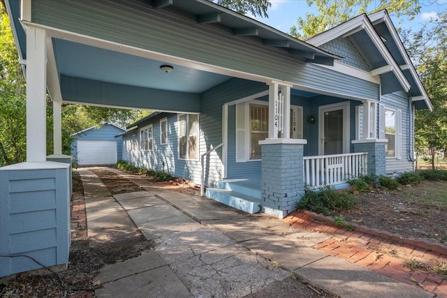 view of front of home featuring an outbuilding, a porch, and a garage