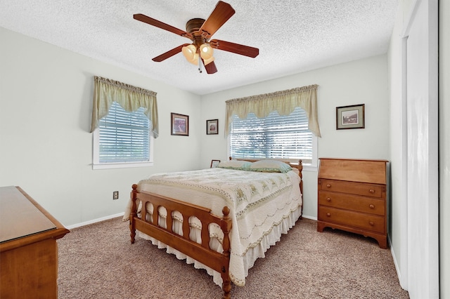 bedroom featuring ceiling fan, light colored carpet, and a textured ceiling