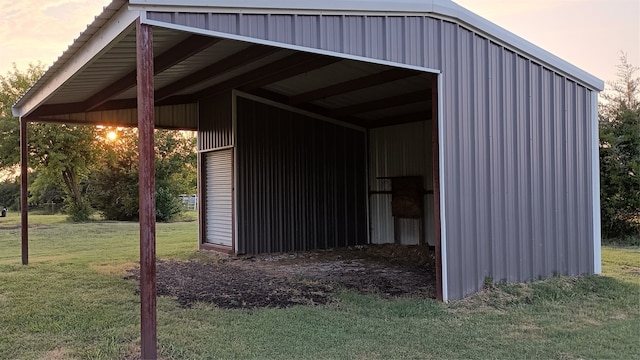 outdoor structure at dusk featuring a lawn