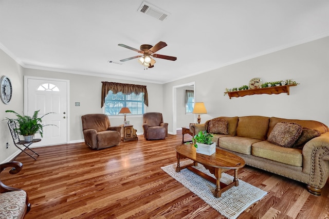 living room with wood-type flooring, crown molding, and ceiling fan