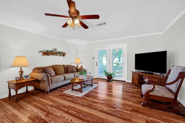 living room with wood-type flooring, ornamental molding, and ceiling fan