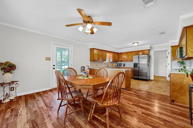 dining room featuring sink, crown molding, hardwood / wood-style flooring, and ceiling fan