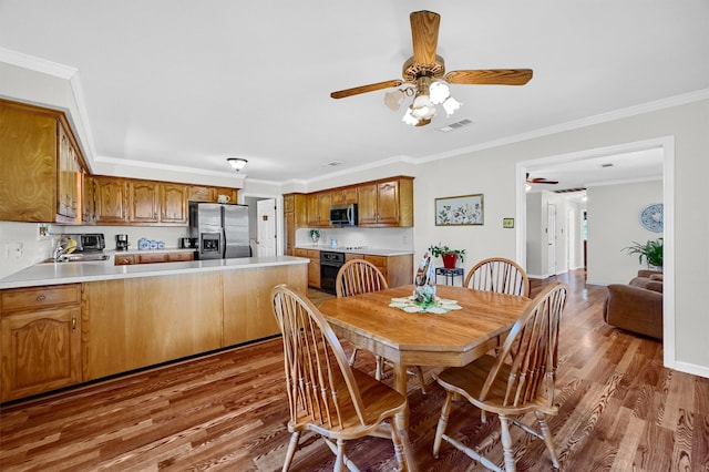 dining space with crown molding, ceiling fan, and hardwood / wood-style floors