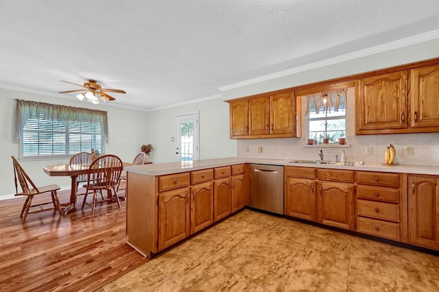 kitchen with dishwasher, sink, ornamental molding, and a healthy amount of sunlight