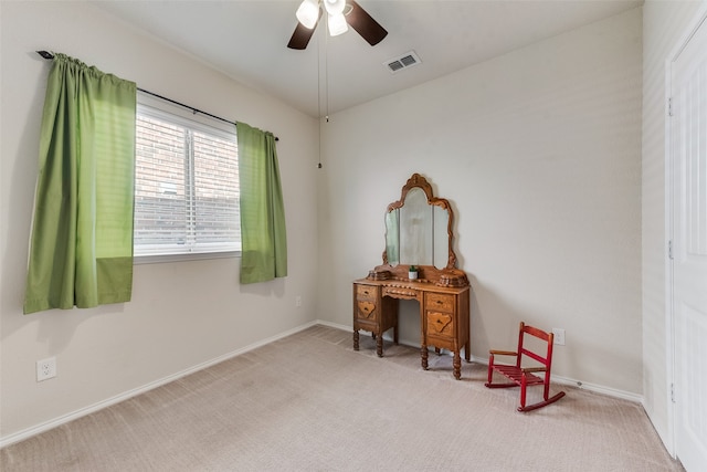 living area featuring light colored carpet and ceiling fan