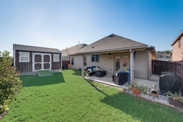 back of house featuring an outdoor living space, ceiling fan, a patio, a storage unit, and a lawn