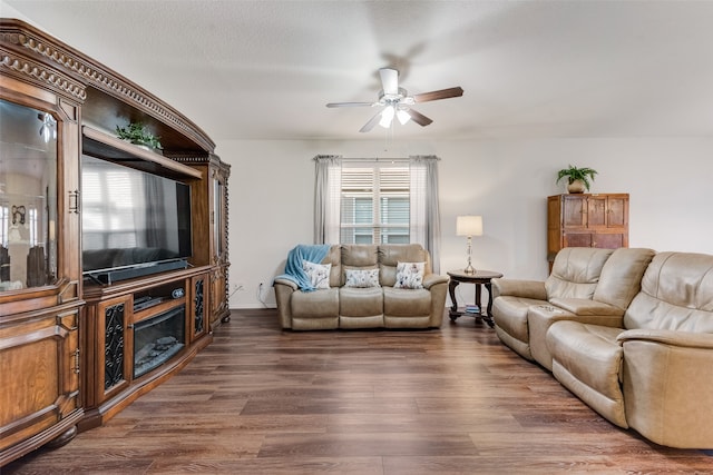 living room featuring ceiling fan, a textured ceiling, a healthy amount of sunlight, and dark hardwood / wood-style floors