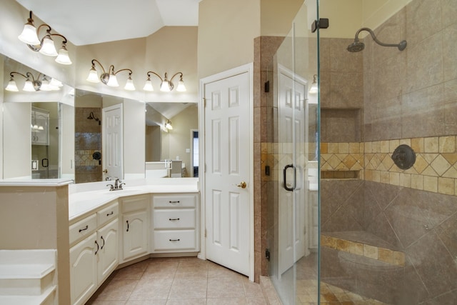 bathroom with a shower with door, vaulted ceiling, tile patterned floors, and vanity