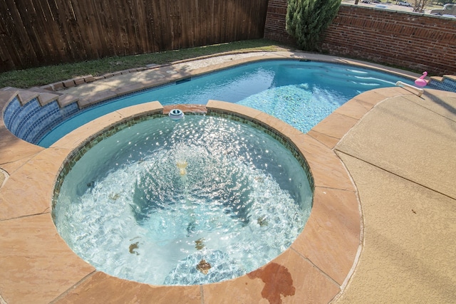 view of pool with an in ground hot tub