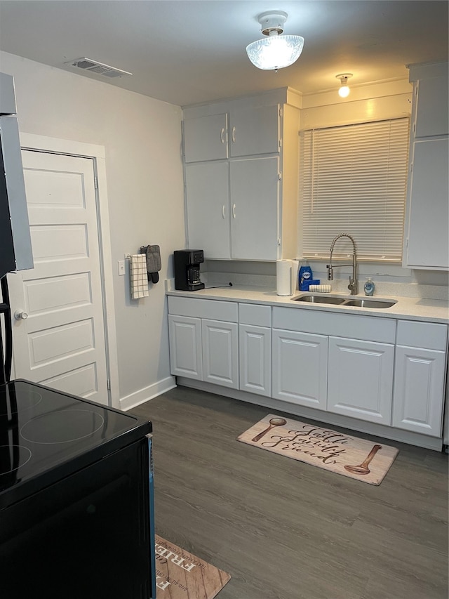 kitchen featuring dark hardwood / wood-style floors, sink, electric range, and white cabinetry