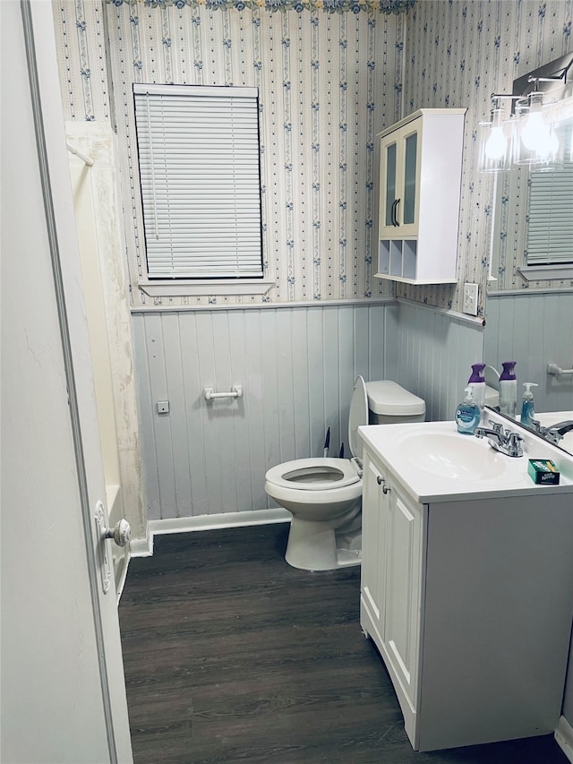 bathroom with vanity, a bathtub, hardwood / wood-style floors, and toilet