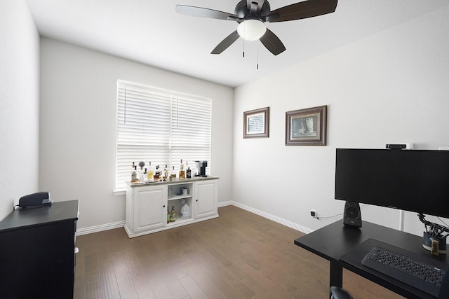 office with dark wood-style floors, a ceiling fan, and baseboards