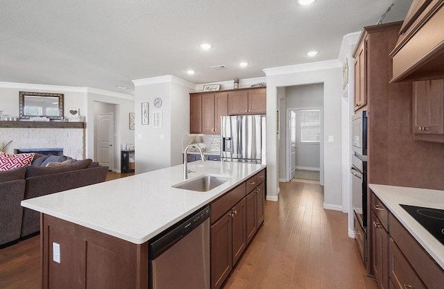 12712 Cold Spring Ln, Ponder, TX 76259 - kitchen with appliances with stainless steel finishes, ornamental molding, light countertops, a stone fireplace, and ventilation hood