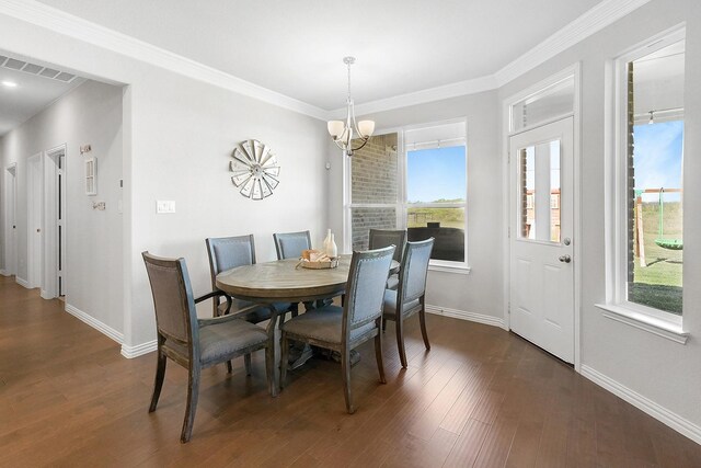 dining space with ornamental molding, dark hardwood / wood-style floors, a wealth of natural light, and a notable chandelier