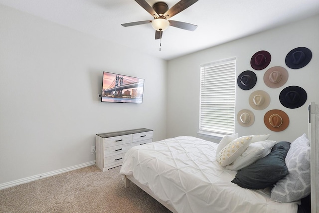 bedroom with ceiling fan, light carpet, and multiple windows