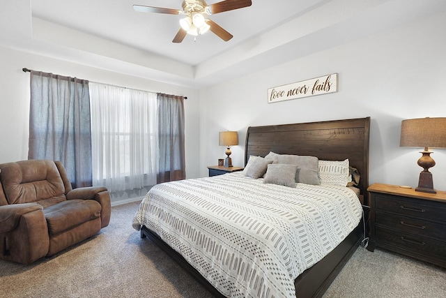 bedroom with a tray ceiling, carpet flooring, and ceiling fan