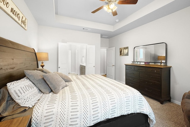 bedroom featuring a raised ceiling, visible vents, light carpet, ceiling fan, and baseboards