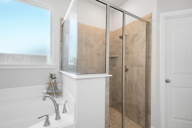 bathroom with shower with separate bathtub and a wealth of natural light