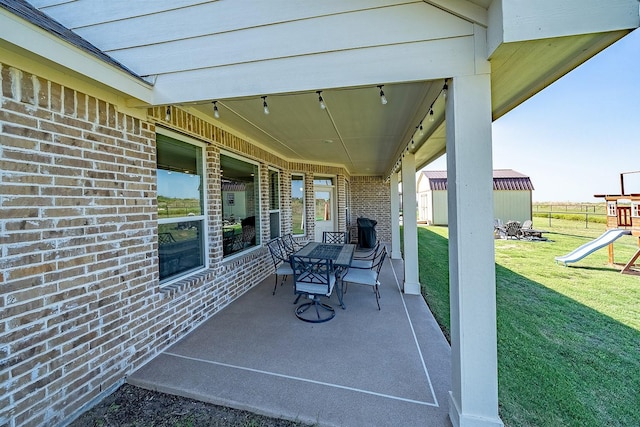 view of patio / terrace with a storage shed, an outdoor structure, a playground, and outdoor dining space