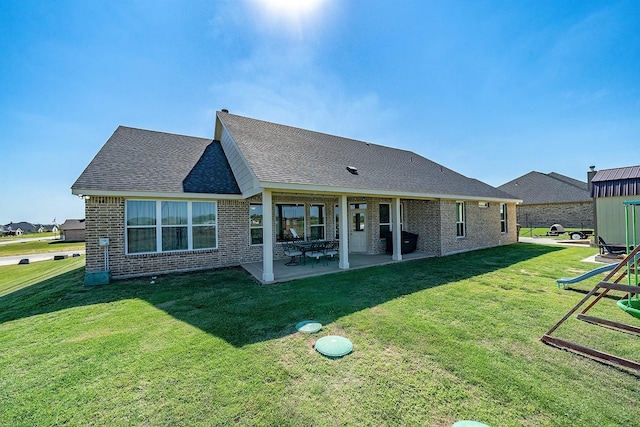 12712 Cold Spring Ln, Ponder, TX 76259 - back of property with brick siding, a patio area, a lawn, and roof with shingles