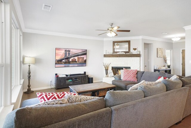 living room featuring crown molding, a fireplace, and ceiling fan