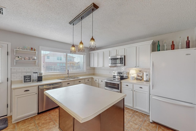 kitchen with sink, white cabinetry, a center island, hanging light fixtures, and stainless steel appliances